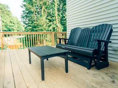 a black bench sitting on a wooden deck at Corton Lodge on the Elk River - Riverview Suite
