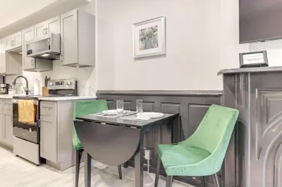 a kitchen with a table and two green chairs at Cincy Apt 1 Mi to Findlay Market, 2 Mi to Downtown in Cincinnati