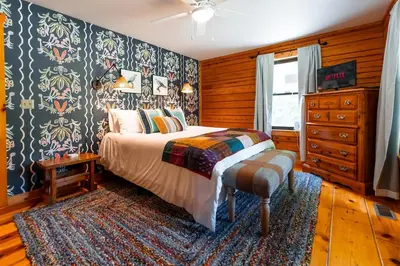 a bedroom with a bed in a room with wooden walls at Havenbrook-Hocking Hills Luxury, 10 Acres, Hot Tub in New Plymouth
