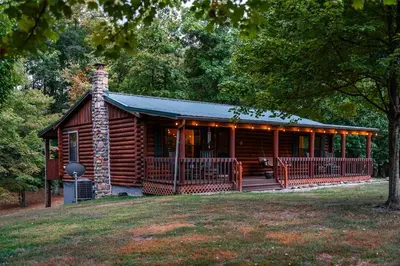 a log cabin with a porch and a deck at Havenbrook-Hocking Hills Luxury, 10 Acres, Hot Tub in New Plymouth
