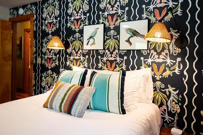 a bed with two pillows in a bedroom with wallpaper at Havenbrook-Hocking Hills Luxury, 10 Acres, Hot Tub in New Plymouth