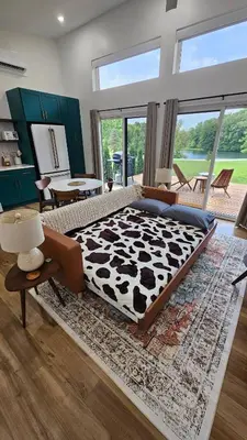 a large bedroom with a cow blanket on a rug at The Mysa - Couples Retreat, Luxe, Sauna, Hot tub in Rockbridge