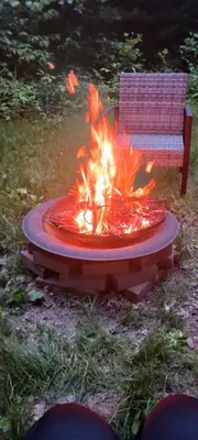 a fire pit in the yard next to a bench at The Reel Freedom Cottage at Leesville Lake in Carrollton