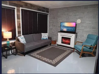 a living room with a couch and a tv and a fireplace at The Reel Freedom Cottage at Leesville Lake in Carrollton