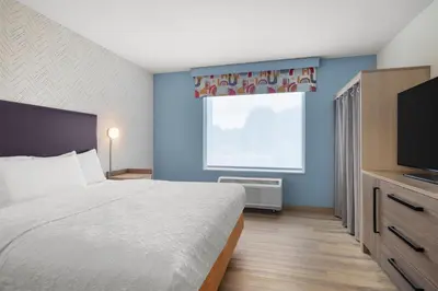 a bedroom with a bed and a window and a television at Home2 Suites By Hilton Muncie in Muncie