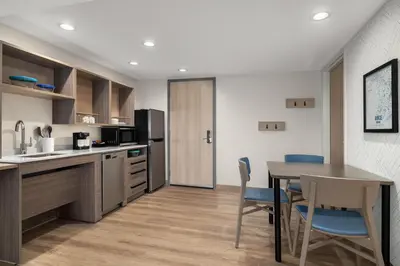 a kitchen and dining room with a table and chairs at Home2 Suites By Hilton Muncie in Muncie