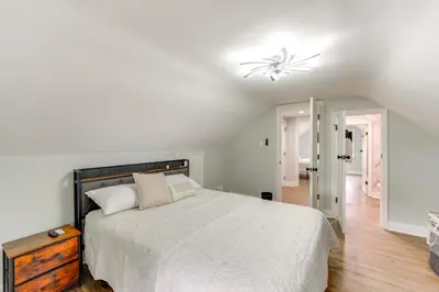 a white bedroom with a bed and a chandelier at 3 Mi to Dtwn Youngstown and YSU Family Home with Yard in Youngstown