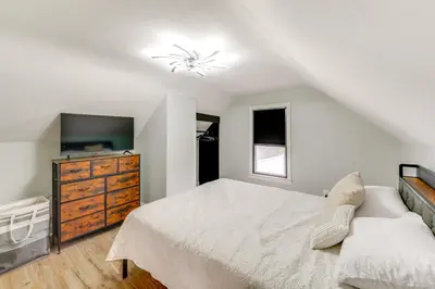 a white bedroom with a bed and a dresser at 3 Mi to Dtwn Youngstown and YSU Family Home with Yard in Youngstown