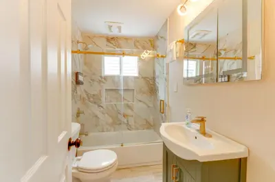 a bathroom with a sink and a toilet and a tub at 3 Mi to Dtwn Youngstown and YSU Family Home with Yard in Youngstown