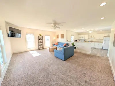 a living room with a blue couch and a kitchen at Cozy Upstairs Unit Near River and Marina Access in Fremont