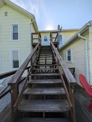 a wooden staircase leading up to a building with a house at Cozy Upstairs Unit Near River and Marina Access in Fremont