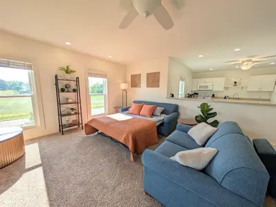 a living room with a blue couch and a table at Cozy Upstairs Unit Near River and Marina Access in Fremont