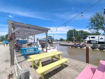 a picnic table on a dock next to a river at Country Charm on the Sandusky Live Music Nearby in Fremont