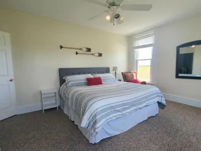 a bedroom with a large bed with red pillows at Country Charm on the Sandusky Live Music Nearby in Fremont