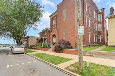 a car parked in a parking lot in front of a brick building at Downtown Apt 23 Mi to Hocking Hills State Park in Lancaster