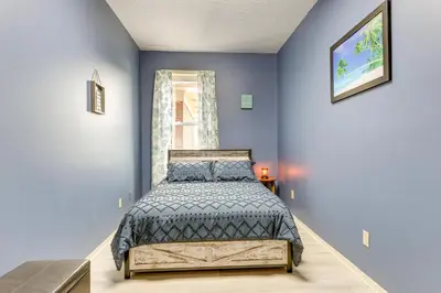 a bedroom with a bed and a blue wall at Downtown Apt 23 Mi to Hocking Hills State Park in Lancaster