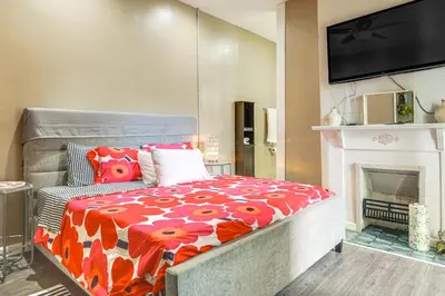 a room with a bed with a fireplace and a television at Walkable Apt in York St Historic District in Newport