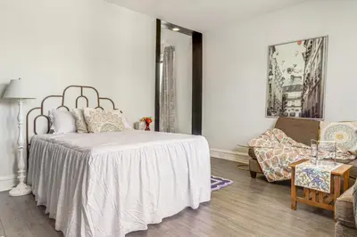 a bedroom with a bed and a chair and a table at Walkable Apt in York St Historic District in Newport