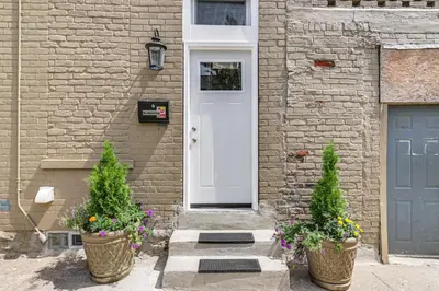 a house with two potted plants in front of a door at Walkable Apt in York St Historic District in Newport