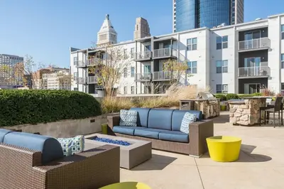 a patio with blue couches and tables and buildings at CozySuites - Current at the Banks in Cincinnati
