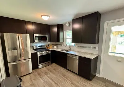 a kitchen with stainless steel appliances and wooden cabinets at Private Home - Entire House - Ranch - Hot Tub - Pets Welcome - 2 King Beds - Kids Welcome - Fenced Yard - Free Wifi - Quiet Neighborhood in Columbus