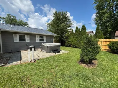 a backyard with a grill and a house at Private Home - Entire House - Ranch - Hot Tub - Pets Welcome - 2 King Beds - Kids Welcome - Fenced Yard - Free Wifi - Quiet Neighborhood in Columbus