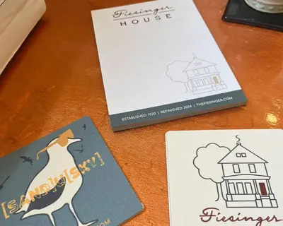 a table with three cards and a book at Fiesinger House - Private 1-bd unit, Historic Home Downtown Sandusky in Sandusky