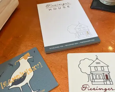 a table with three cards and a book at Fiesinger House - Private 1-bd unit, Historic Home Downtown Sandusky in Sandusky