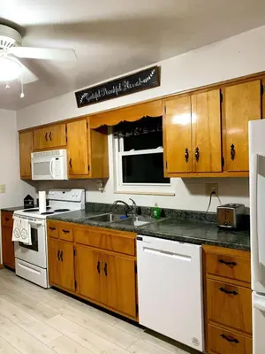 a kitchen with wooden cabinets and a white stove top oven at Bridgeport House WV, Close to UHC, FBI, The Bridge Complex in Bridgeport
