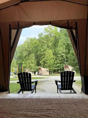 two chairs sitting under a tent in a park at Safari Tent Glamping in Kentucky with AC and Access to Biking Trails in Grayson