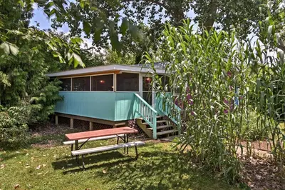 a green house with a bench in front of it at Resort Cabin 1 Mi to Middle Bass Island State Park in Middle Bass