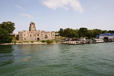 a building with a tower on the side of a river at Resort Cabin 1 Mi to Middle Bass Island State Park in Middle Bass