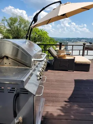 a grill on a deck with an umbrella at Luxe Mt Adams Lookout in Cincinnati
