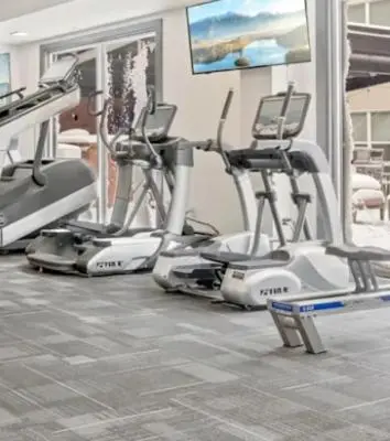 a gym with three exercise bikes in a room at Beautiful in Beachwood in Beachwood