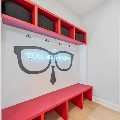 a red bench in a room with a columbus roots sign at Hot Tub - Mins to Short North - Retro Game Room in Columbus