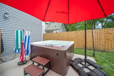 a red umbrella and two chairs under a hot tub at Hot Tub - Mins to Short North - Retro Game Room in Columbus