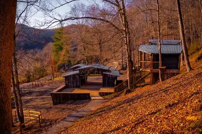 a park with benches and a building on a hill at Ohio Starlight Glamping Cabins - A Peaceful Woodland Retreat