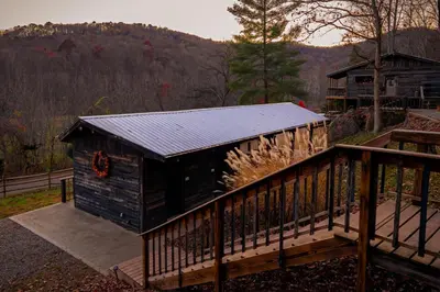 a wooden cabin with a porch and a deck at Ohio Starlight Glamping Cabins - A Peaceful Woodland Retreat
