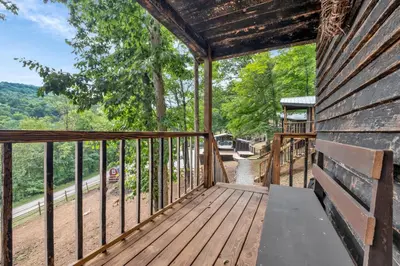 a cabin with a balcony with a view of a road at Ohio Starlight Glamping Cabins - A Peaceful Woodland Retreat