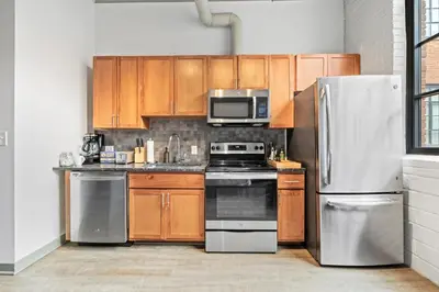 a kitchen with wooden cabinets and stainless steel appliances at Studio at Superior l Downtown l Parking l Café in Cleveland
