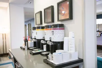 a counter with a coffee maker and cups on it at Hampton Inn Toledo Oregon in Oregon