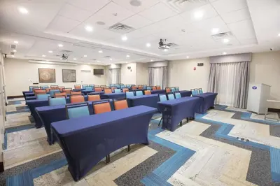 a conference room with blue chairs and a podium at Hampton Inn Toledo Oregon in Oregon