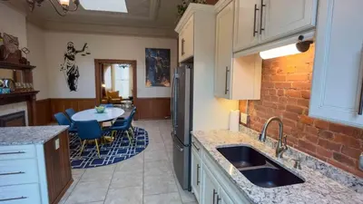 a kitchen with a sink and a brick wall at Court St Suite in Clarksburg