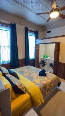 a bedroom with a large bed and a washing machine at Court St Suite in Clarksburg