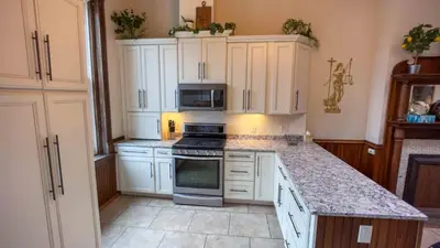 a kitchen with white cabinets and a stove top oven at Court St Suite in Clarksburg