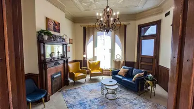 a living room with a blue couch and yellow chairs at Court St Suite in Clarksburg