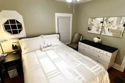 a bedroom with a large white bed and a dresser at Fiesinger House - Entire Historic Home, Downtown Sandusky in Sandusky