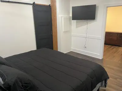 a bedroom with a black bed and a flat screen tv at Apartment in Newark in Newark