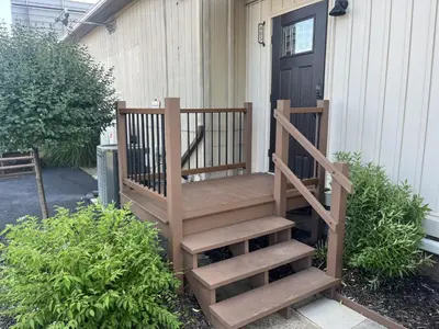 a wooden staircase leading to a house with a door at Apartment in Newark in Newark