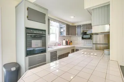 a kitchen with gray cabinets and a white tiled floor at Grand Lake Getaway with Boat Dock in St Marys!